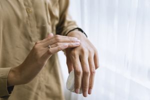 woman putting moisturizer on her hands